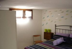 トッレ・デイ・コルサリにあるDomu Noaのベッドルーム1室(青と紫の掛け布団付きのベッド1台付)