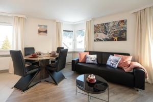 Agrimonia - möbilierte Ferienwohnung mit Balkon في دافوس: غرفة معيشة مع أريكة وطاولة