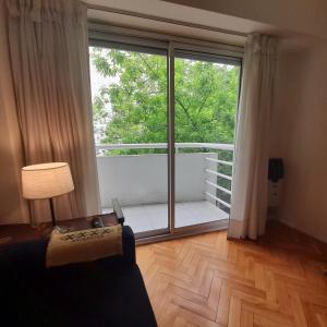 sala de estar con ventana grande y balcón en Departamento céntrico con cochera. en Buenos Aires