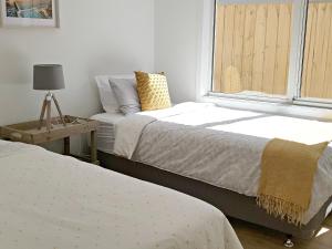 two beds in a room with a window at ADAGIO in Point Lonsdale
