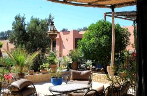 a patio with chairs and a table and an umbrella at Maison Marocaine Agadir in Agadir
