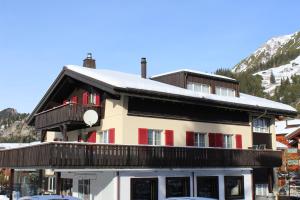 a building with a balcony with snow on the roof at Ferienwohnungen Walserhof Malbun in Malbun