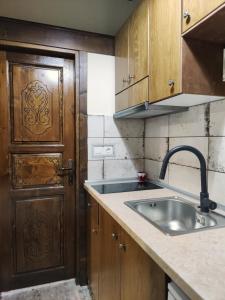 eine Küche mit einem Waschbecken und einer Holztür in der Unterkunft Guesthouse Theodorou in Elati, Trikala