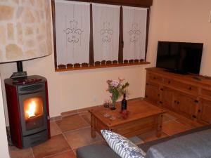 sala de estar con chimenea y TV en Casa Rural El Dolmen, en Bernúy-Salinero