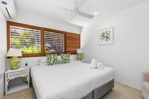 a bedroom with a large white bed and a window at Crest Premium View Apartment 32 in Noosa Heads