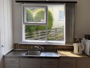 uma cozinha com um lavatório e uma janela em Peppermint Retreat Taroona em Taroona