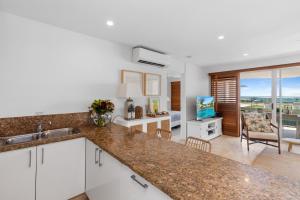 a kitchen with a counter top and a living room at Crest Premium View Apartment 32 in Noosa Heads