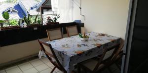 uma mesa de jantar com cadeiras e uma toalha de mesa em "Le Caraïbe" T3 à Bas du Fort au Gosier à quelques pas de la plage em Le Gosier