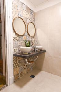 a bathroom with two sinks and mirrors on the wall at Cambacuá in Buenos Aires