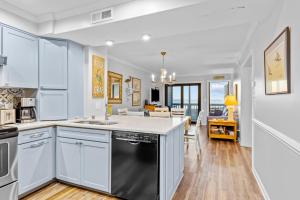 una cucina con armadietti bianchi e lavastoviglie nera di Dunescape Villas 211 ad Atlantic Beach