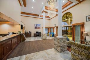 a living room with a lobby with a stone fireplace at SureStay Hotel by Best Western Mt Pleasant in Mount Pleasant