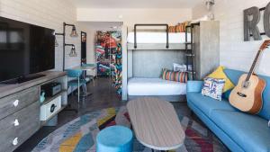 a living room with a blue couch and a bed at Egyptian Motor Hotel BW Signature Collection in Phoenix