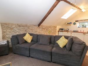 a living room with a couch and a stone wall at The Loft in Buxton