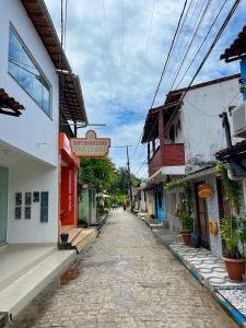 an empty street with a sign on the side of a building at Pousada Maré Alta em Boipeba in Ilha de Boipeba