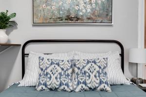uma cama com uma almofada azul e branca e um quadro em G3 central location museums FREE PARKING em Richmond