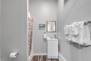 uma casa de banho branca com um lavatório e um espelho em G3 central location museums FREE PARKING em Richmond