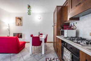 cocina con silla roja, mesa y fogones en Delizioso flat in centro storico - Free WiFi & Netflix en Massa Lombarda
