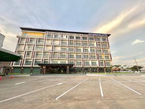 a large building with a parking lot in front of it at S.R.SUNSHINE HOTEL in Ban Sok Dua