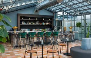 a bar with green chairs and tables in a room at The LINE San Francisco in San Francisco