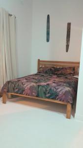 a bed with a wooden frame in a room at Hakuna Studios Barra do Sahy in Barra do Sahy