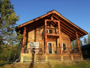 a log cabin with a wrap around deck at Villa Lummelahti House on the shore of Lake Saimaa in Pettilä