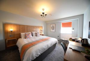 a bedroom with a large bed and a desk at Park Head Hotel in Bishop Auckland