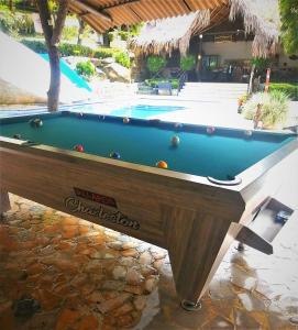 a pool table in front of a swimming pool at Hostal Villa Cata in El Zaino