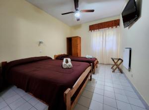 a bedroom with two beds and a flat screen tv at Hotel Los Ángeles in San Clemente del Tuyú +36 photos