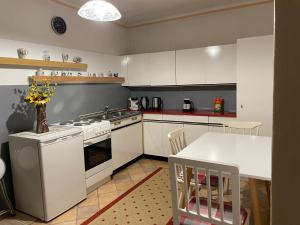 a kitchen with white cabinets and a white table and a table and a tablektop at Cheap Outlet Center Apartment with Pool in Parndorf