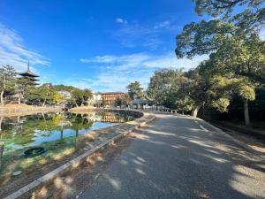 a road in a park with a pond and trees at Old modern house in Nara Second in Nara
