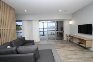 a living room with a couch and a table with a television at Waterfront Apartments in Devonport