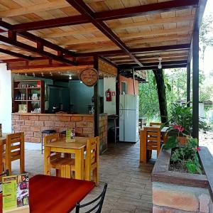 a patio with wooden tables and chairs and a kitchen at Sendero de las aves in Mindo