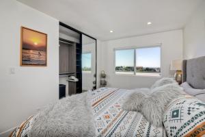 恩西尼塔斯的住宿－Ocean View, Luxury 2BR 2BA, Private Rooftop Patio，一间卧室设有一张床和两个窗户。