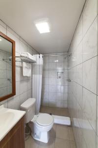 ein Bad mit einem WC, einer Dusche und einem Waschbecken in der Unterkunft American Inn in Baton Rouge