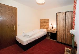 a small bedroom with a bed and a desk at Panorama Landhaus in Saalbach Hinterglemm