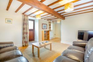 a living room with a couch and a table at Bwythyn-y-Wennol in Abersoch
