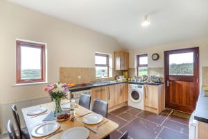 a kitchen with a table with flowers on it at Bwythyn-y-Wennol in Abersoch