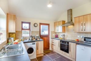 a kitchen with a sink and a dishwasher at Bwythyn-y-Wennol in Abersoch