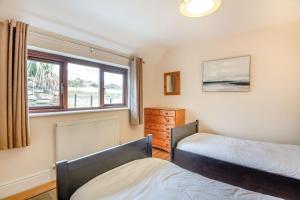 a bedroom with two beds and a window at Bwythyn-y-Wennol in Abersoch