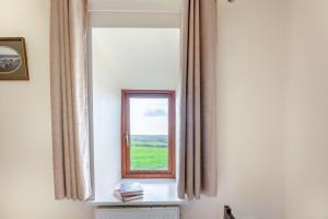 a mirror in a room with a window at Bwythyn-y-Wennol in Abersoch