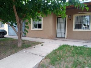 una acera frente a una casa con un árbol en Departamento Benielli en San Rafael