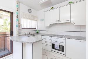 a kitchen with white cabinets and a counter top at Carinya Gardens 15 in Forster