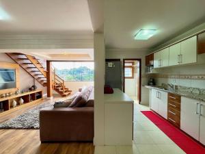 cocina y sala de estar con sofá en una habitación en Apartamentos Dioserra CENTRO by Achei Gramado, en Gramado