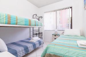 a bedroom with two bunk beds and a window at Carinya Gardens 15 in Forster