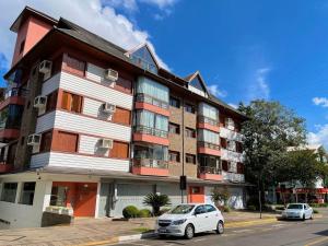 un condominio con auto parcheggiate di fronte di Apartamentos Dioserra CENTRO by Achei Gramado a Gramado