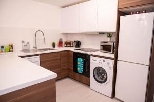 cocina con nevera blanca y lavavajillas en Panorama House, Delightful 2-Bedroom Flat 1, Oxford, en Kidlington