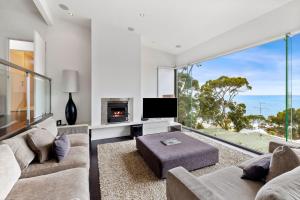 a living room with a couch and a tv at Summerhills House - BYO Linen in Lorne
