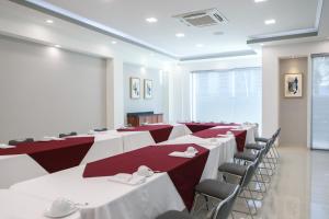 a conference room with tables and chairs and a screen at Hotel Fray Select in Tepic