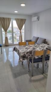 - une salle à manger avec une table, des chaises et un canapé dans l'établissement Bahia sin fondo, à Puerto Madryn