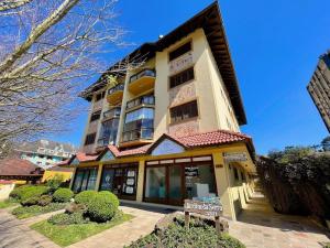 un edificio con una señal delante de él en Apartamentos Jardim da Serra CENTRO by Achei Gramado, en Gramado